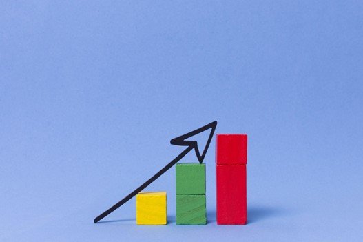 Wooden blocks forming an ascending bar chart with an upward arrow